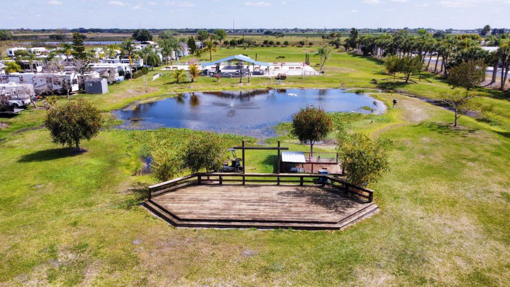 Starlite RV Park with pond and wide grass fields on an aerial view